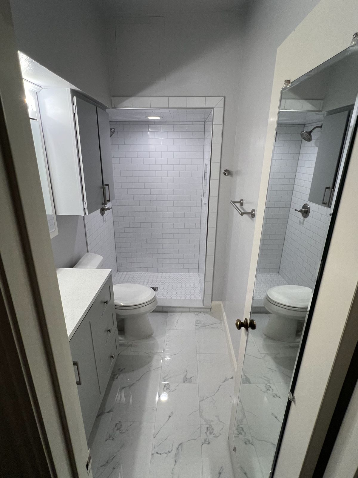 Hall bathroom with white subway tile walk-in shower and new vanity
