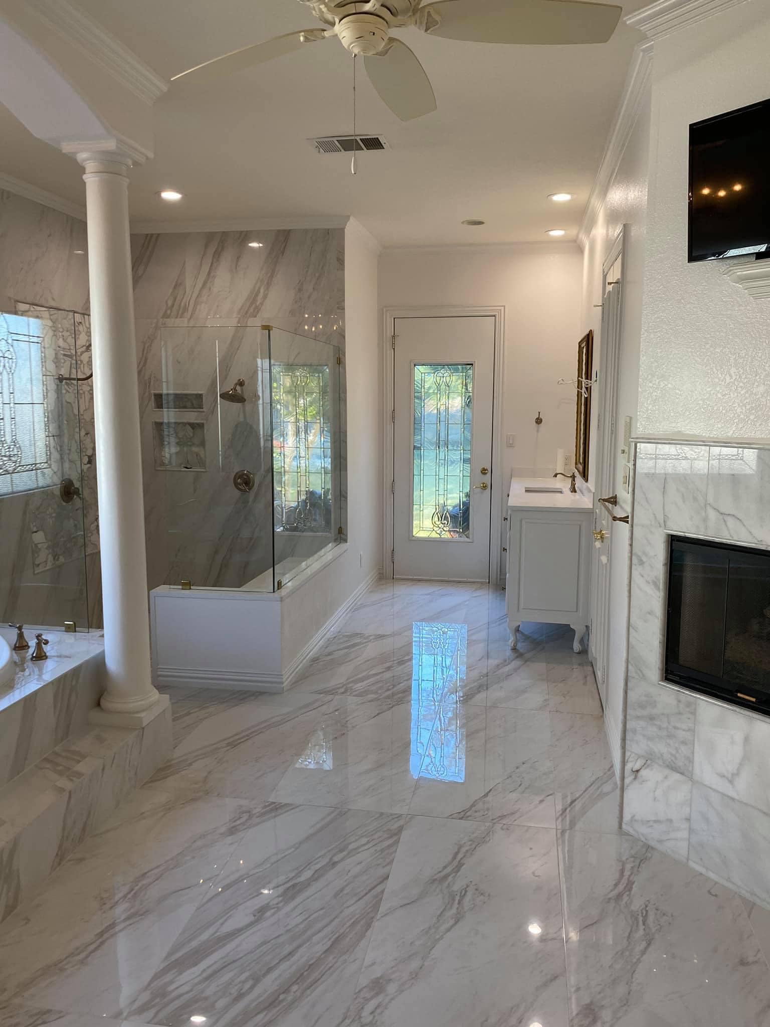 Luxury master bathroom remodel with marble tile, columns and glass shower in Colleyville