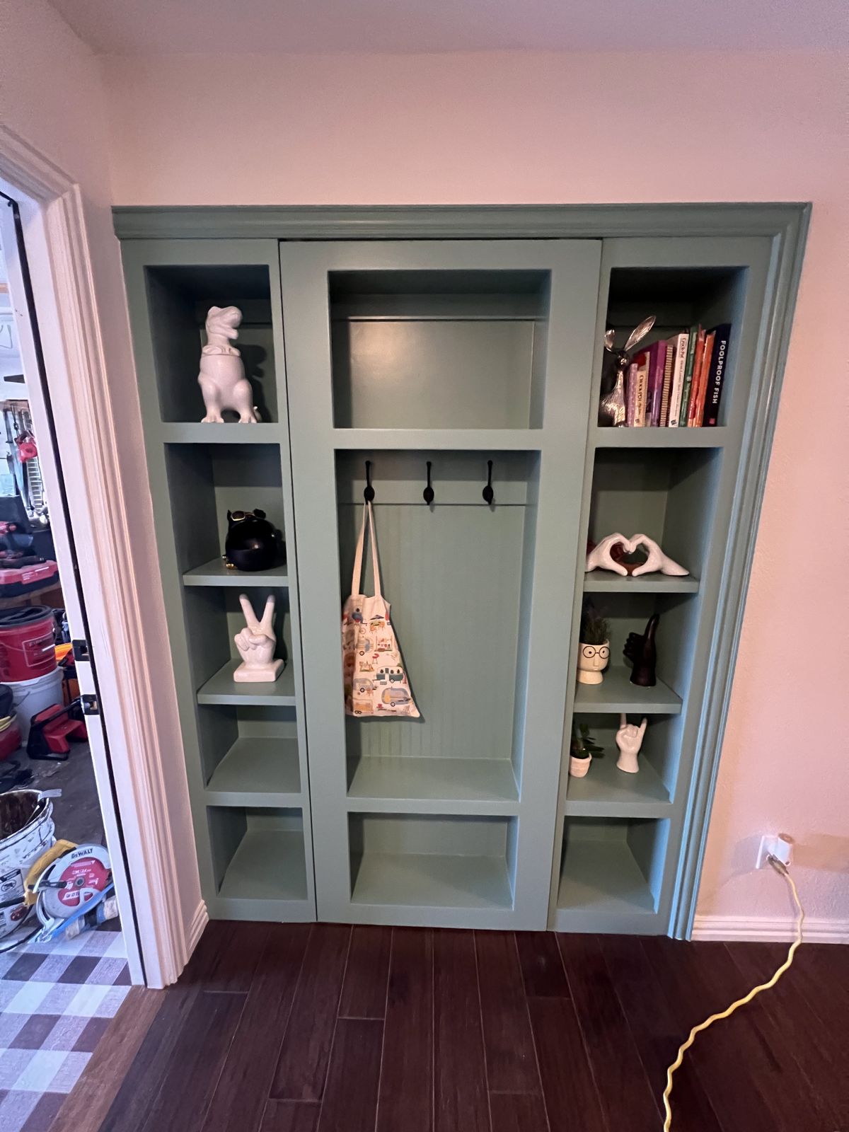 Custom painted mudroom locker built-in with hooks and shelving