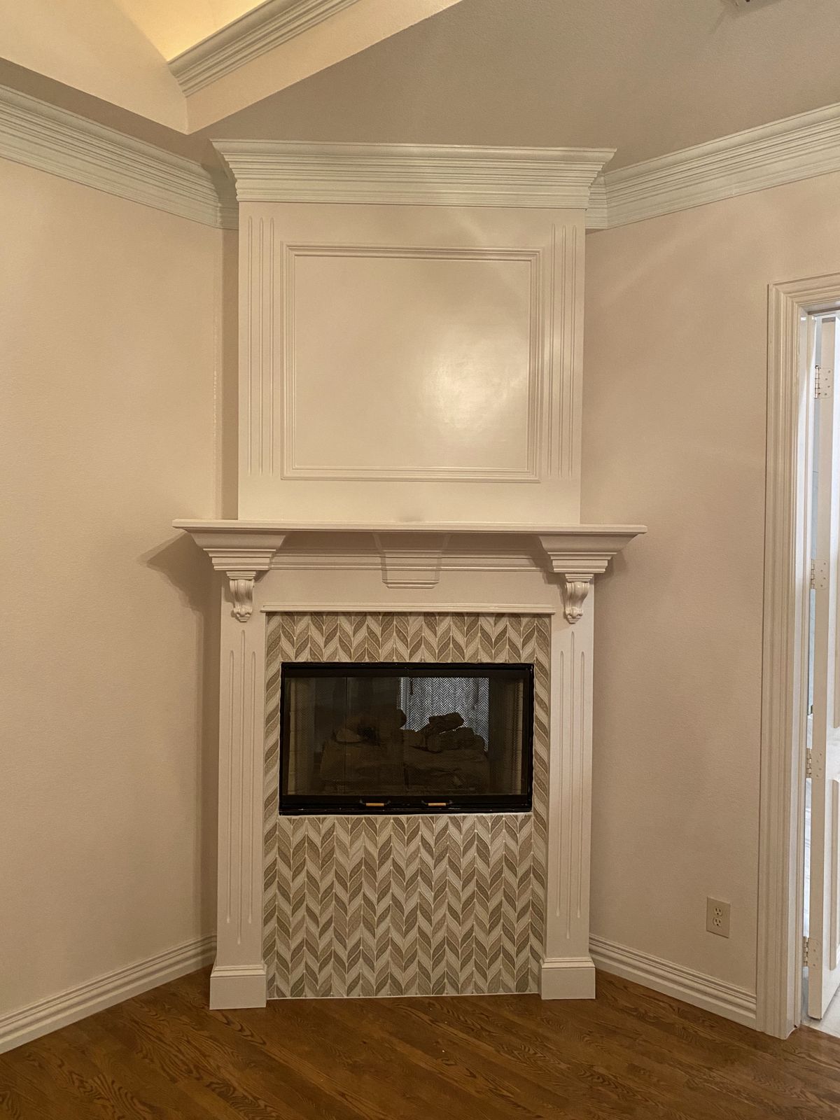 Fireplace with custom mantel, trim and herringbone tile surround