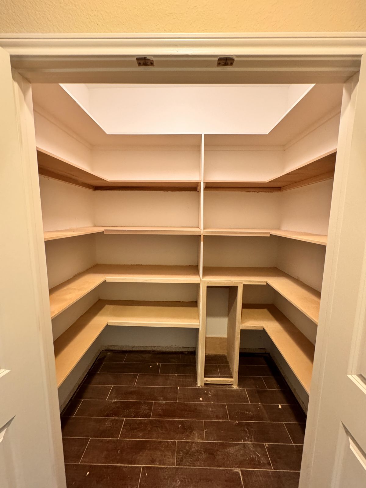 Walk-in pantry with custom wood shelving