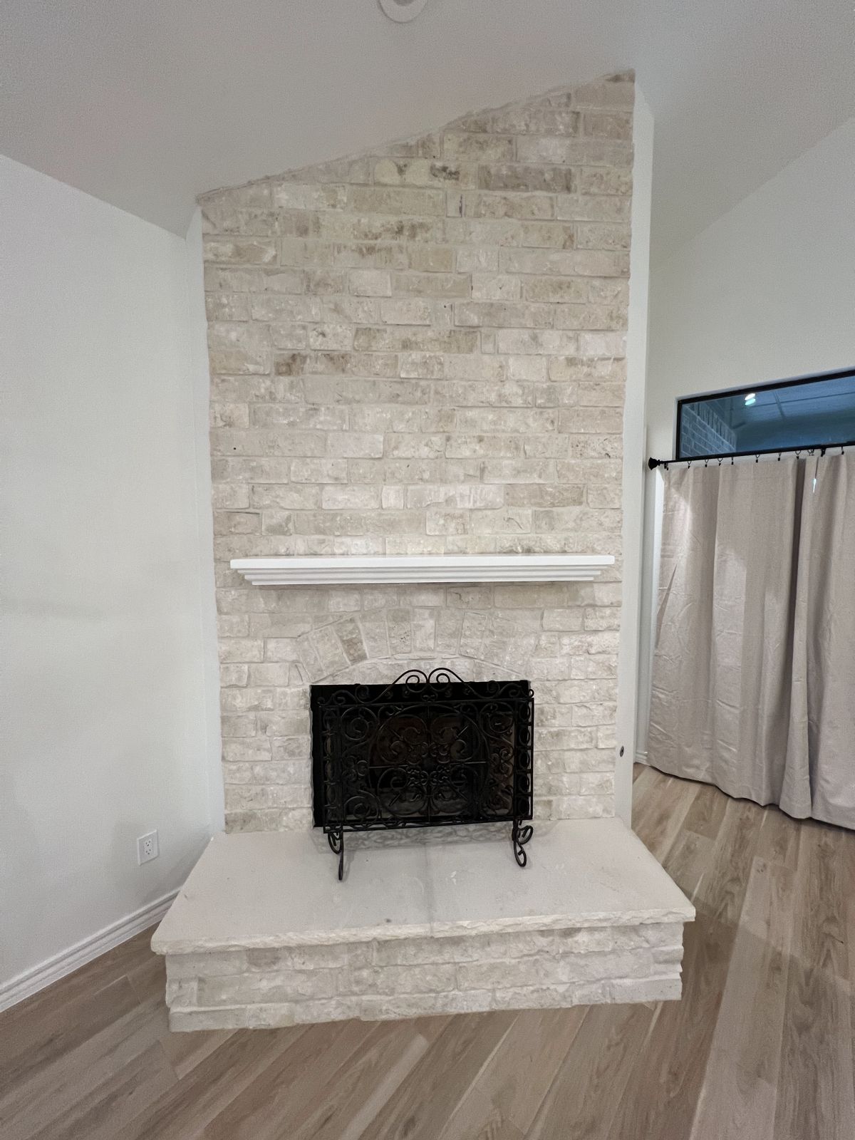 Floor-to-ceiling stacked stone fireplace with raised hearth